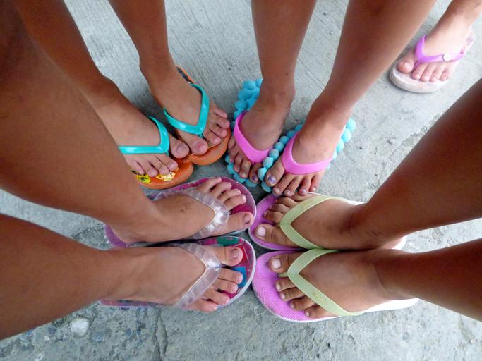 Ženské nohy vo farebných šľapkách s namaľovanými nechtami v kruhu
